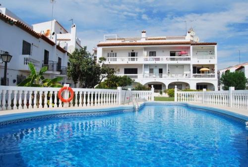a swimming pool in front of a building at Hacienda 22 MENYBER in Nerja