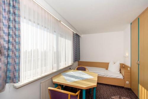 a small room with a bed and a table at Gästehaus im Haus des Kfz-Gewerbes in Dresden