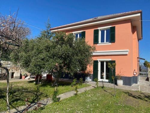 a pink house with trees in front of it at Una casa nel verde sulle colline di Lavagna in Crocetta