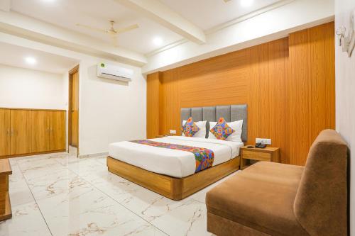 a hotel room with a bed and a chair at FabHotel Raj Villa - Nr Tri mandir in Jāmb