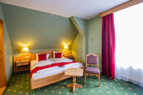 a bedroom with a bed and a table and a chair at Hotel Schloss Nebra in Nebra