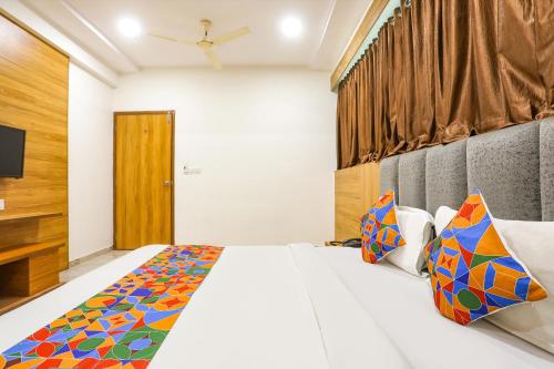 a bedroom with a large bed and a tv at FabHotel Raj Villa - Nr Tri mandir in Jāmb