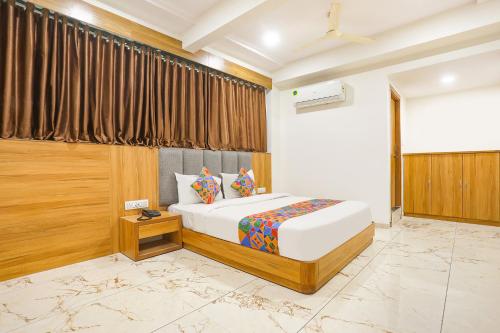 a hotel room with a bed and a window at FabHotel Raj Villa - Nr Tri mandir in Jāmb