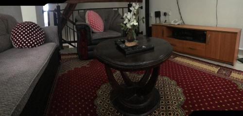 a living room with a table with flowers on it at Ella Aman Vanicia Resort in Ella