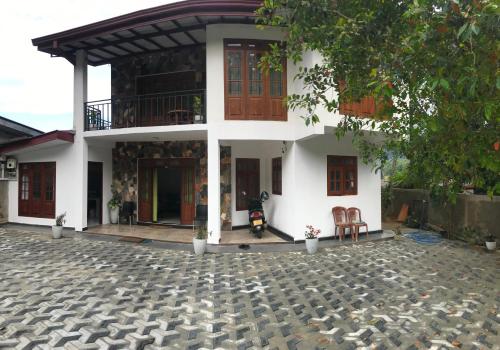 a house with a motorcycle parked in front of it at Ella Aman Vanicia Resort in Ella