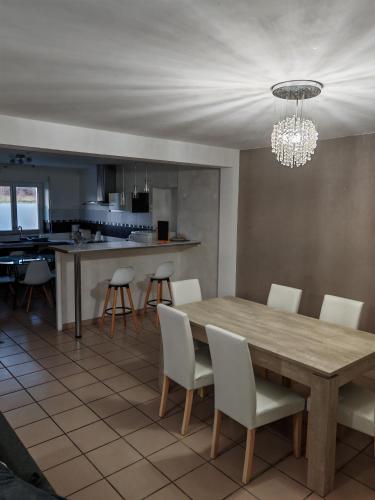 - une salle à manger et une cuisine avec une table et des chaises en bois dans l'établissement Maison de campagne sur puyoo, à Puyoô