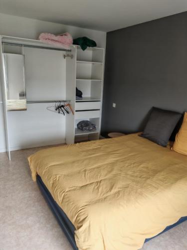 - une chambre avec un grand lit et une grande couverture jaune dans l'établissement Maison de campagne sur puyoo, à Puyoô