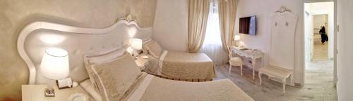 a white bedroom with a bed and a table and a desk at Alloggio Turistico GIULIETTA e Romeo - INTERO APPARTAMENTO - Villafranca di Verona, Zimmer, Holiday Rooms in Villafranca di Verona