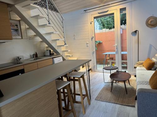 a kitchen and living room with a staircase in a house at Maison cosy, wifi terrasse, proche plage, gare, centre in Arcachon