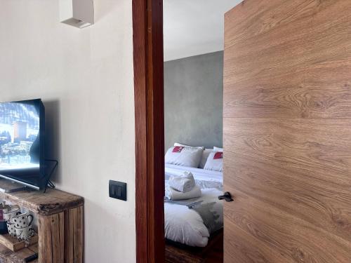 a room with a bedroom with two beds and a door at Belle Vue - GestingHome in Sestriere
