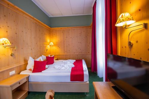 a small room with a bed with red pillows at Hotel Schloss Nebra in Nebra