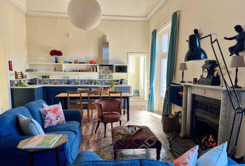 a living room with a blue couch and a fireplace at Artist's Studio in Piddlehinton