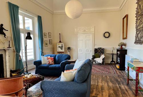 a living room with two blue couches and a fireplace at Artist's Studio in Piddlehinton