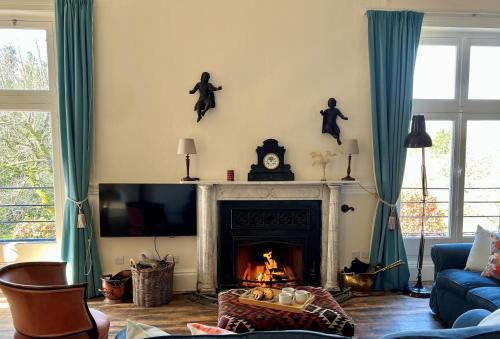a living room with a fireplace and a tv at Artist's Studio in Piddlehinton