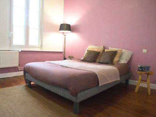 une chambre avec un lit avec un mur rose dans l'établissement La Vue Cathédrale - Grande maison en hypercentre, Idéal Groupe, à Saint-Omer