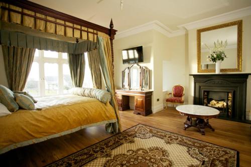 a bedroom with a large bed and a fireplace at St Columbs House in Buncrana