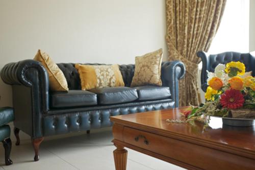 Sala de estar con sofá azul y mesa de centro en St Columbs House, en Buncrana