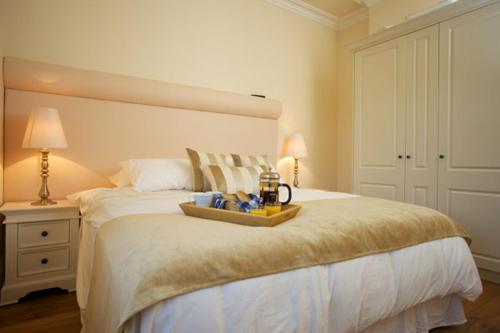 a bedroom with a large white bed with a tray on it at St Columbs House in Buncrana