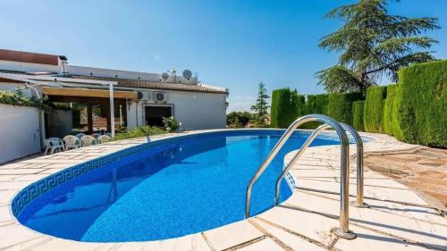 a swimming pool in front of a house at Spacious Villa with Private Pool in Monachil in Monachil