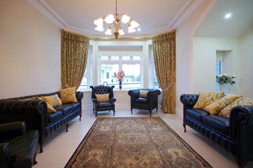 a living room with couches and chairs and a chandelier at St Columbs House in Buncrana