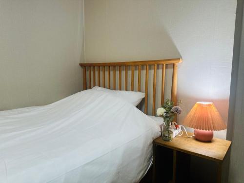 a bedroom with a bed and a lamp on a table at Stay Cozy Corner Gangnam, Suseo, Ilwon-dong, Samsung Hospital, a 7-minute walk from Daecheong Statio in Seoul