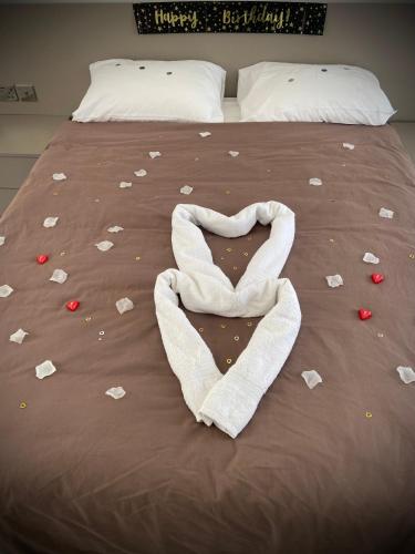 a bed with a heart made out of paper on it at Penelope Apartments 15 in Xlendi