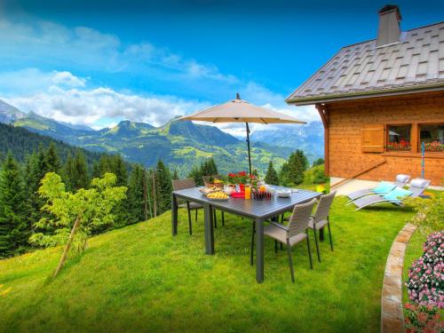 マニグードにあるChalet de Paul et Marie - OVO Networkの山の芝生の上に傘をさすテーブル
