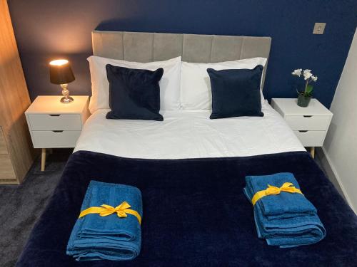 a bedroom with a bed with two blue and yellow bows on it at Central Doncaster 1BED 1BATH Pent-Apartment in Doncaster