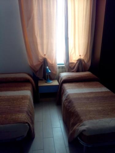 a hotel room with two beds and a window at Hotel Niagara in Caselle Torinese