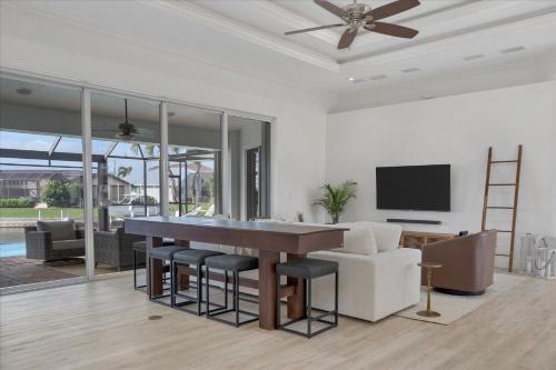 a dining room with a table and chairs and a tv at SAN3337 Canalfront Vacation Pool Home in Punta Gorda