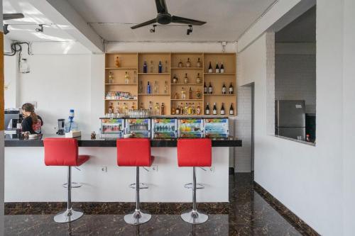 a bar with red chairs in a restaurant at Margarita Surf Hostel Canggu in Canggu