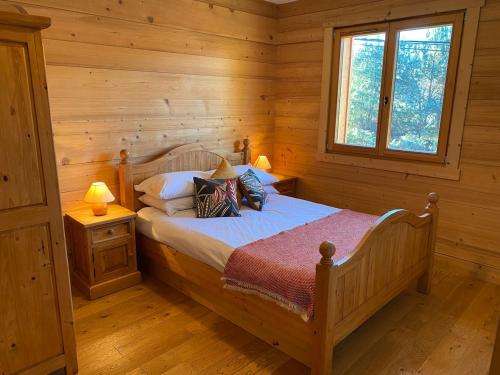 a bedroom with a bed in a log cabin at Chalet Pip - Modern chalet with breathtaking views in Morzine