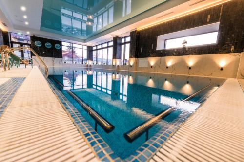 a swimming pool in a building with a swimming pool at Pensiunea Parâng in Târgu Jiu