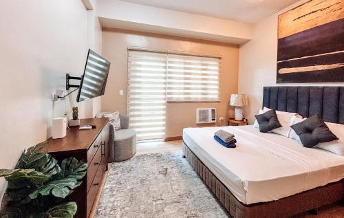 a bedroom with a bed and a desk and a window at Your Luxury Studio Escape in Iloilo City