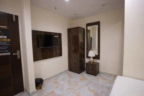a room with a bed and a television on a wall at Hotel Blissful in Thane