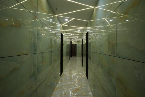 a hallway of a building with lights on the walls at Hotel Blissful in Thane
