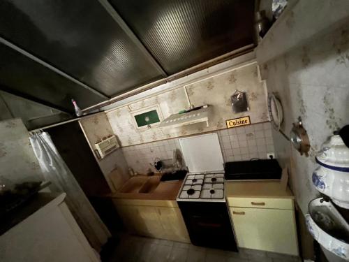 Il comprend une petite cuisine équipée d'une cuisinière et d'un évier. dans l'établissement Maison 3 chambres, à Roubaix