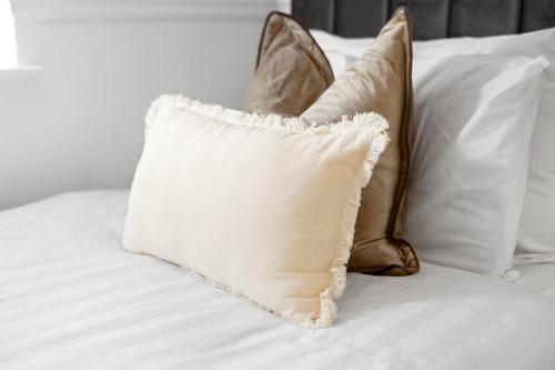 a pile of pillows sitting on a bed at Modern Four Bed House - Parking - Garden - Netflix 802W in Birmingham