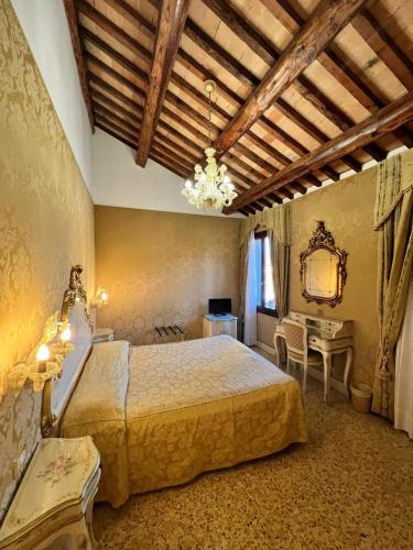 a bedroom with a bed and a table and a mirror at Hotel Ca' Dogaressa in Venice