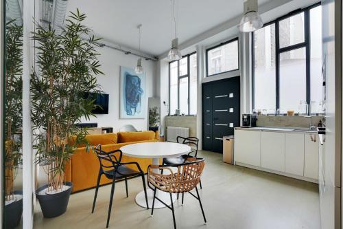 une cuisine et un salon avec une table et des chaises dans l'établissement Duplex Loft Montmartre -18th, à Paris