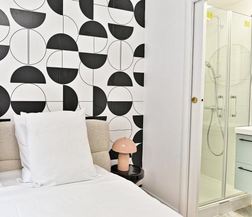 - une chambre avec un lit blanc et un mur noir et blanc dans l'établissement Maisonette 5 minutes from Paris Levallois III, à Levallois-Perret