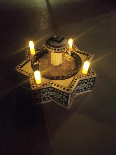 a table with two candles and a cake on top at Gite d'étape nomade in Tajda