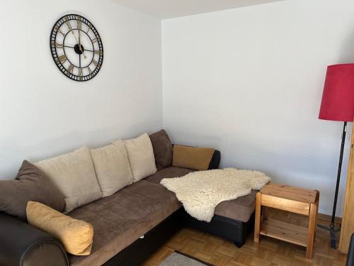 a living room with a couch and a clock on the wall at annelise in Leukerbad