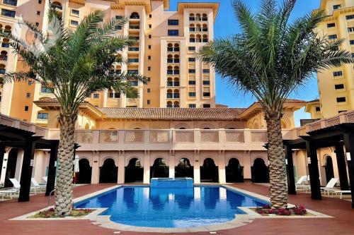 a hotel with palm trees in front of a building at Serene 2-Bed Haven in Jumeirah Golf Estates in Dubai