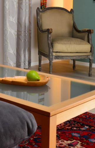 a glass coffee table with a chair and a green apple on it at Haus Farbenklang in Zwiesel