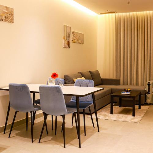 a living room with a table and chairs and a couch at BHomed Shaab in Kuwait