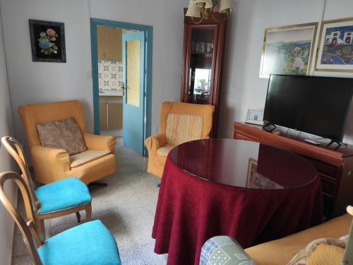 a living room with a table and chairs and a television at LA CASA AZUL -Mancha Real, Jaen, Úbeda, Baeza- in Mancha Real