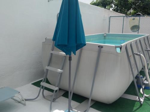 an umbrella sitting next to a bath tub at LA CASA AZUL -Mancha Real, Jaen, Úbeda, Baeza- in Mancha Real