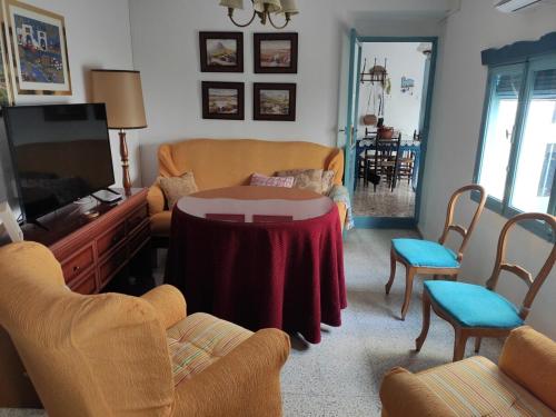 a living room with a table and chairs and a tv at LA CASA AZUL -Mancha Real, Jaen, Úbeda, Baeza- in Mancha Real
