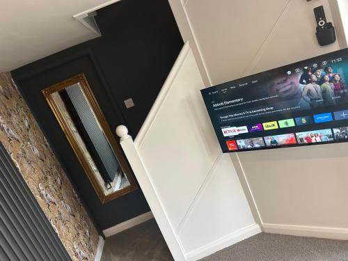a flat screen tv hanging on a wall next to a staircase at Aiskew Villa Annex in Bedale